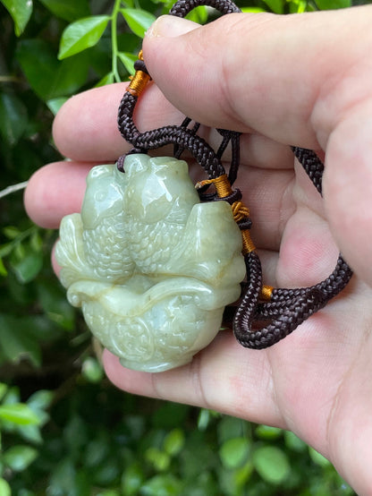 Untreated Type A Burmese jade pendant showing glossy translucent luster with beautiful apple green colors on an adjustable cord