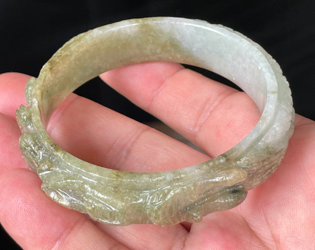 Close-up of a 58.9mm certified natural Grade A Burmese jadeite bangle featuring icy apple and forest green hues with a hand-carved dragon motif, item JB208
