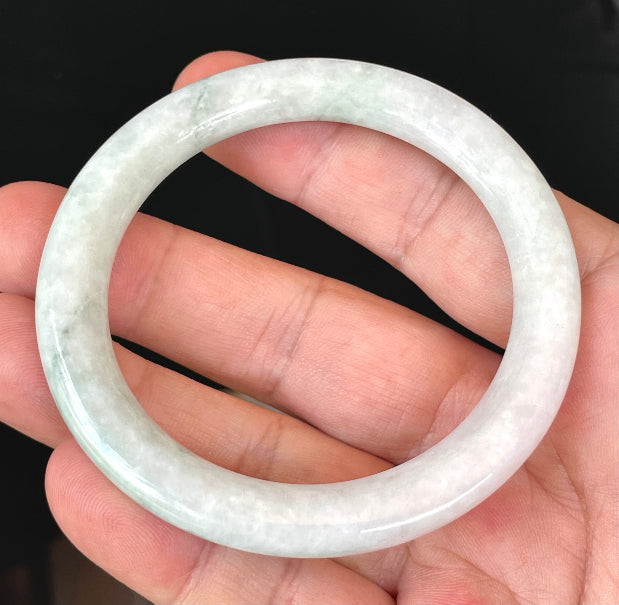 Solid icy white and apple green natural Type A Burmese jade bangle bracelet in a flat round style, size 56.5mm