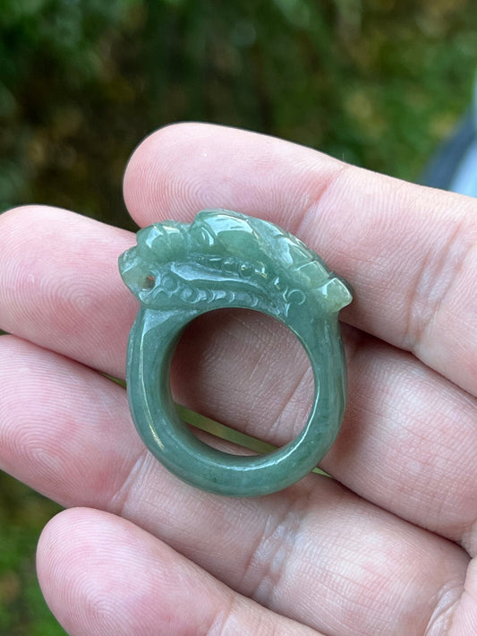Hand holding a Size US 9 Grade A Burmese jadeite ring featuring a detailed hand-carved dragon motif in soft icy apple green, item JDR001