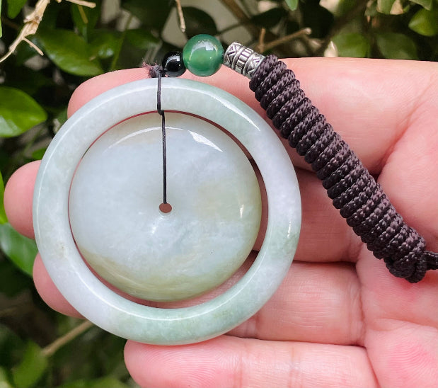 Untreated Type A Burmese jade pendant showing semi-translucent luster with beautiful green and white colors on a handcrafted cord