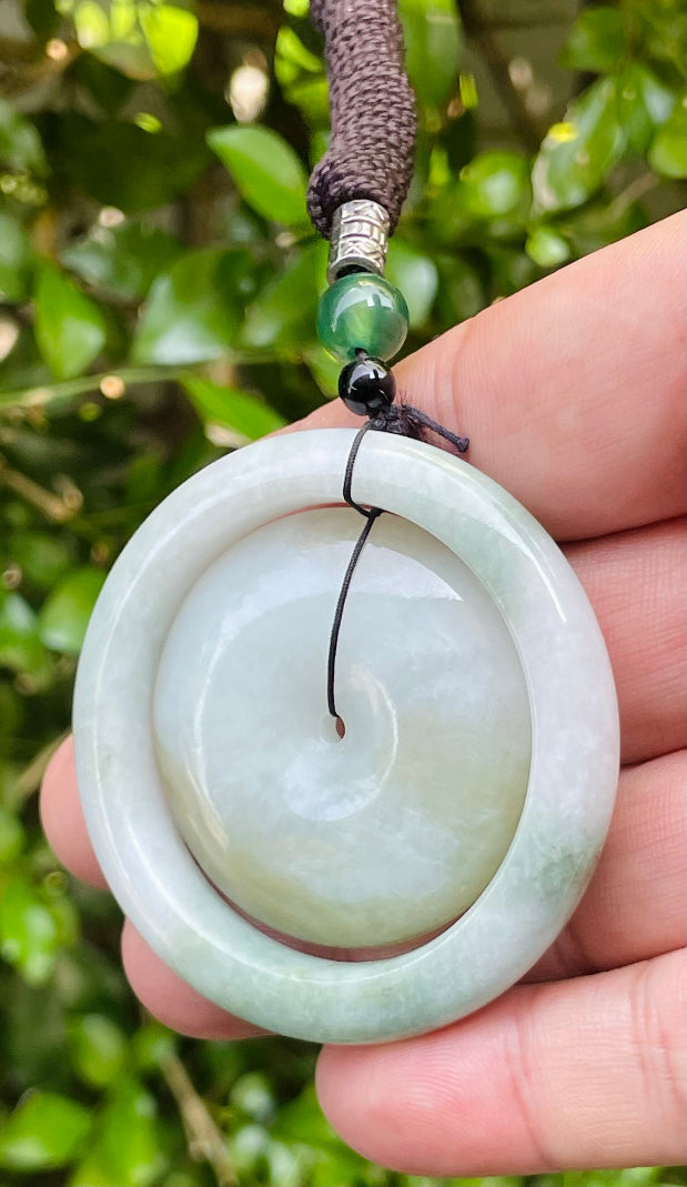 Untreated Type A Burmese jade pendant showing semi-translucent luster with beautiful green and white colors on a handcrafted cord