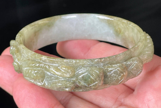 Solid icy green and milky white natural Type A Burmese jade bangle bracelet with carved dragon design, size 58.9mm