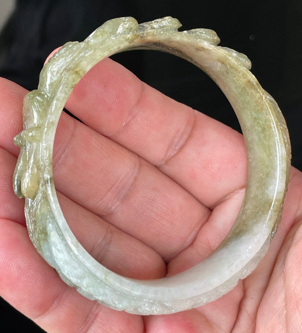 Solid icy green and milky white natural Type A Burmese jade bangle bracelet with carved dragon design, size 58.9mm