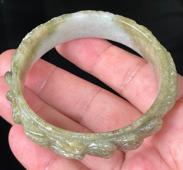 Solid icy green and milky white natural Type A Burmese jade bangle bracelet with carved dragon design, size 58.9mm