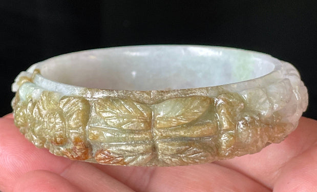 Solid icy forest green and honey orange natural Type A Burmese jade bangle bracelet with carved floral design, size 58.7mm