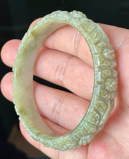 Solid icy apple green and milky white natural Type A Burmese jade bangle bracelet with carved floral design, size 57.4mm