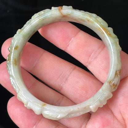 Solid icy apple green, milky white, and honey orange natural Type A Burmese jade bangle bracelet with carved floral design, size 57mm