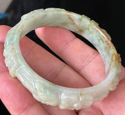 Solid icy apple green, milky white, and honey orange natural Type A Burmese jade bangle bracelet with carved floral design, size 57mm