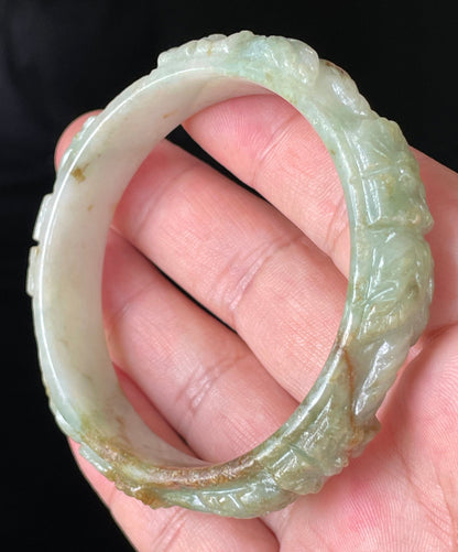 Solid icy apple green, milky white, and honey orange natural Type A Burmese jade bangle bracelet with carved floral design, size 57mm