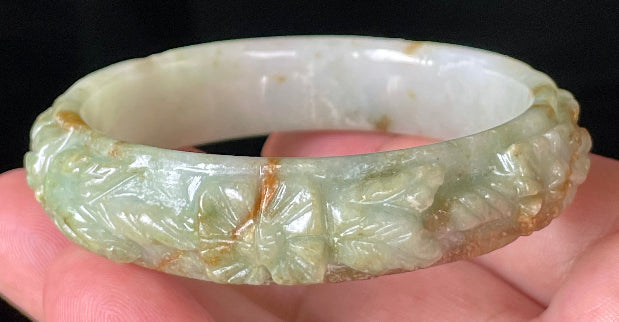 Solid icy apple green, milky white, and honey orange natural Type A Burmese jade bangle bracelet with carved floral design, size 57mm
