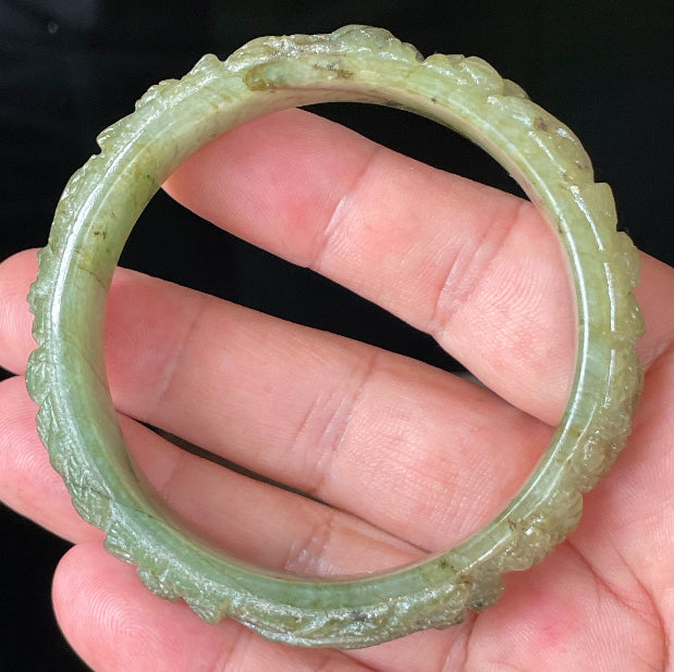 Solid icy apple green natural Type A Burmese jade bangle bracelet with carved floral design, size 58.3mm