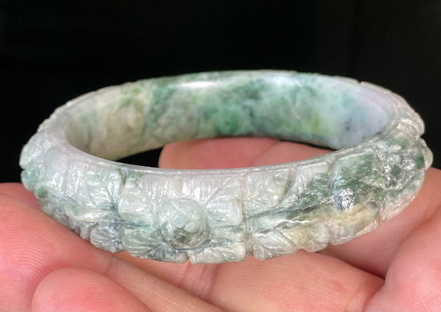 Solid icy emerald and imperial green natural Type A Burmese jade bangle bracelet with carved floral design, size 56mm