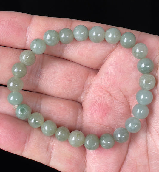 Hand-shaped 8mm natural Type A Burmese jade beads showing gentle translucency and icy green colors on the wrist
