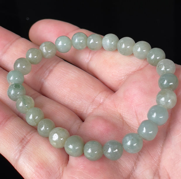 Hand-shaped 8mm natural Type A Burmese jade beads showing gentle translucency and icy green colors on the wrist