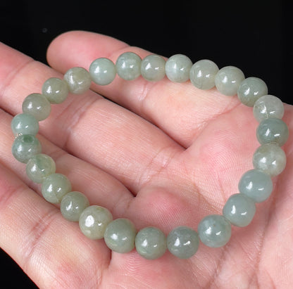Hand-shaped 8mm natural Type A Burmese jade beads showing gentle translucency and icy green colors on the wrist