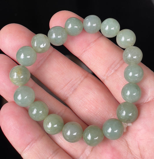 Hand-shaped 10.5mm natural Type A Burmese jade beads showing gentle translucency and icy green colors on the wrist