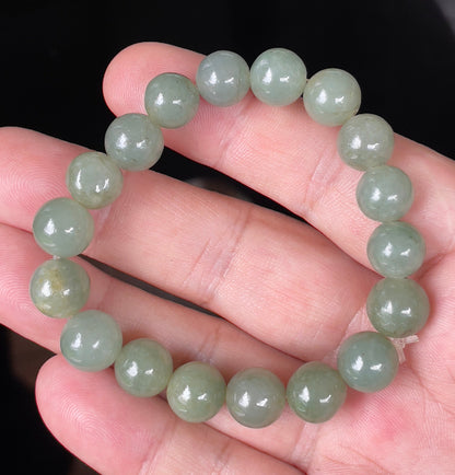 Hand-shaped 10.5mm natural Type A Burmese jade beads showing gentle translucency and icy green colors on the wrist