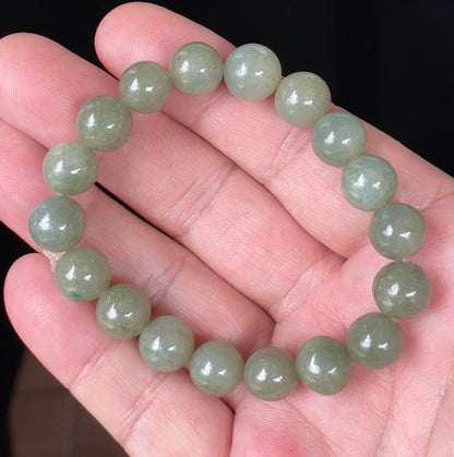 Hand-shaped 10.4mm natural Type A Burmese jade beads showing a serene icy green color on the wrist