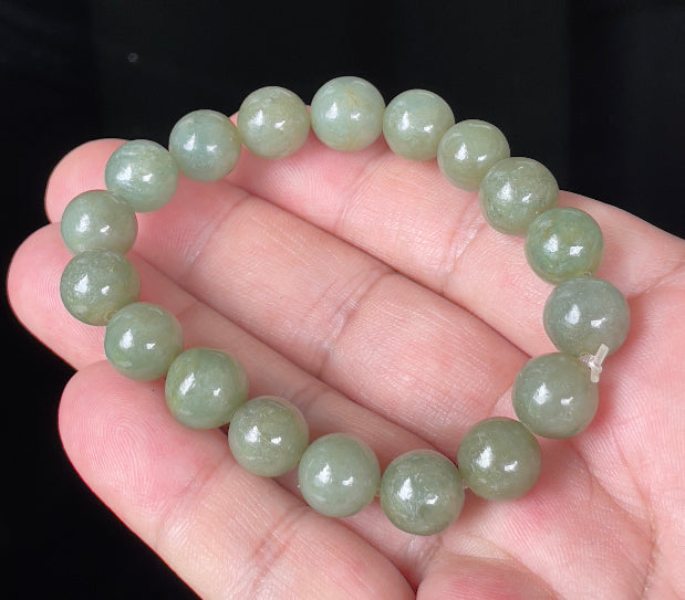 Hand-shaped 10.4mm natural Type A Burmese jade beads showing a serene icy green color on the wrist