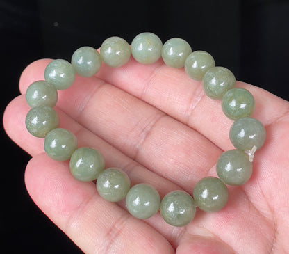 Hand-shaped 10.4mm natural Type A Burmese jade beads showing a serene icy green color on the wrist