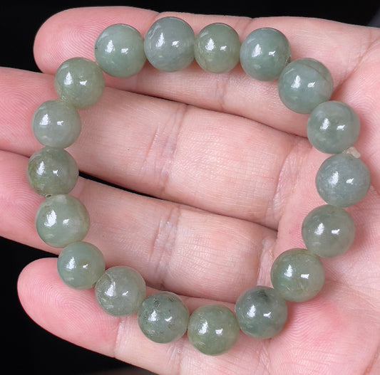 Hand-shaped 10.3mm natural Type A Burmese jade beads showing gentle translucency and icy green colors on the wrist