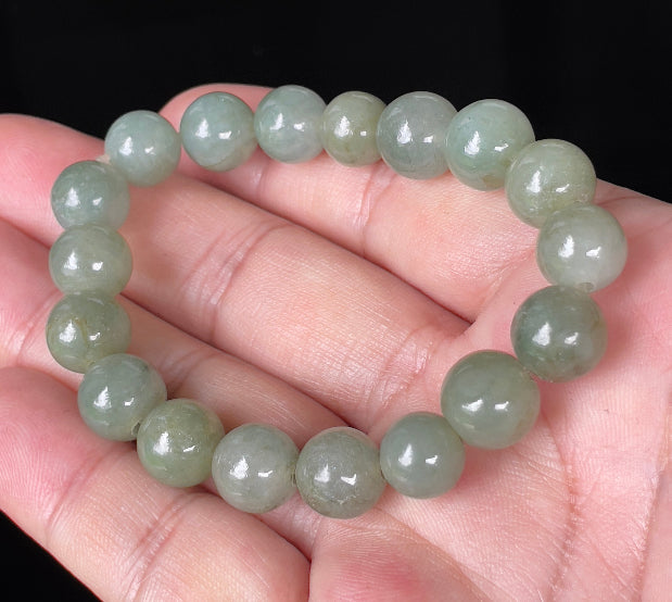 Hand-shaped 10.3mm natural Type A Burmese jade beads showing gentle translucency and icy green colors on the wrist