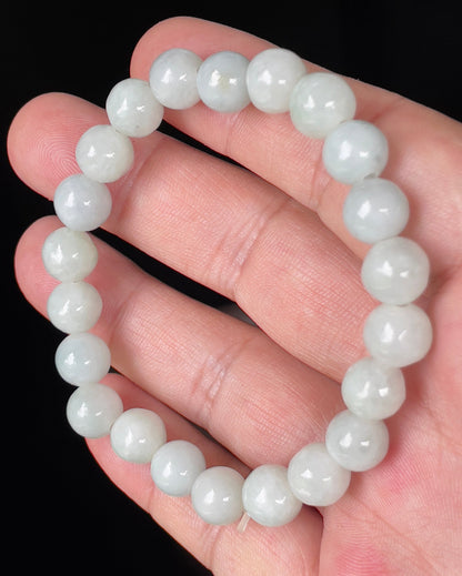 Hand-shaped 9.7mm natural Type A Burmese jade beads showing gentle translucency with icy green and white colors on the wrist