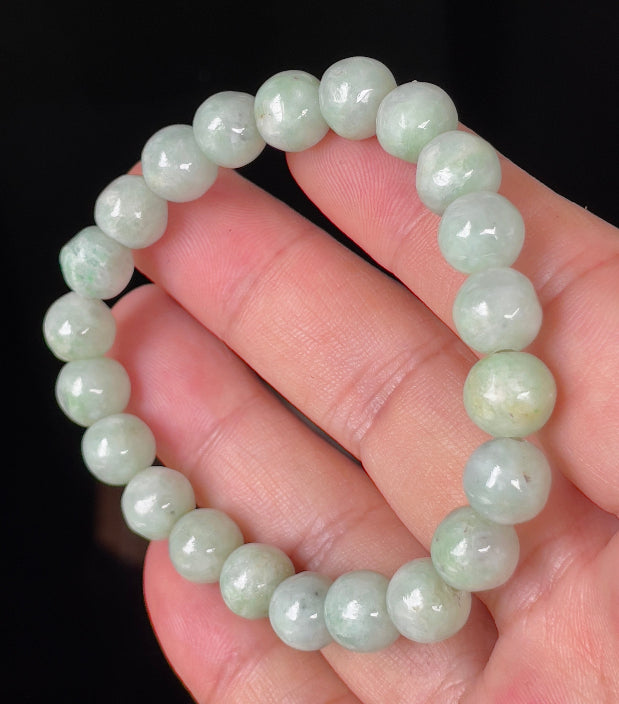 Hand-shaped 9.5mm natural Type A Burmese jade beads showing gentle translucency and icy green colors on the wrist
