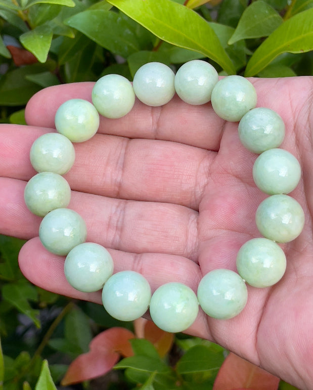 13.4mm natural Type A Burmese jade beads showing translucent to semi-opaque luster with beautiful icy apple and forest green hues on the wrist