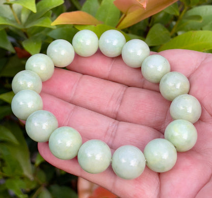 13.4mm natural Type A Burmese jade beads showing translucent to semi-opaque luster with beautiful icy apple and forest green hues on the wrist