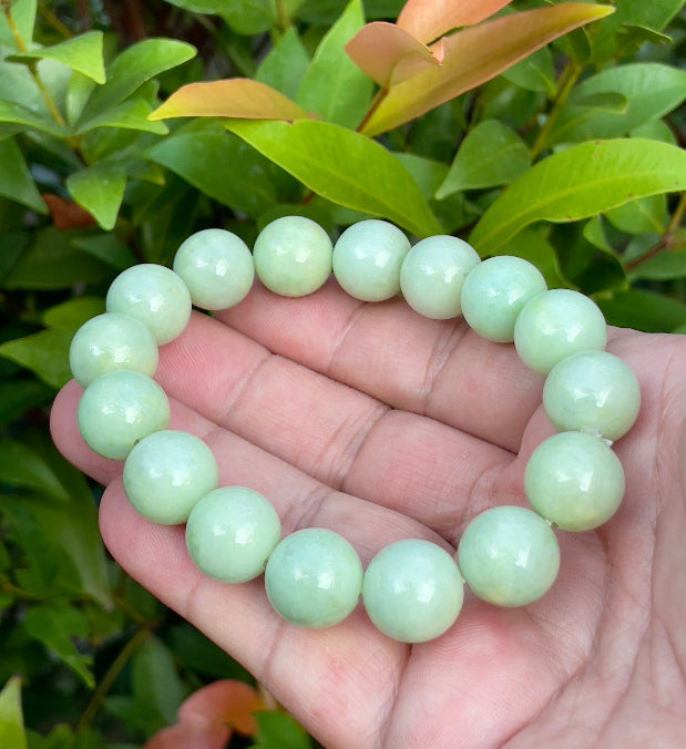 13.4mm natural Type A Burmese jade beads showing translucent to semi-opaque luster with beautiful icy apple and forest green hues on the wrist