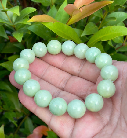 13.4mm natural Type A Burmese jade beads showing translucent to semi-opaque luster with beautiful icy apple and forest green hues on the wrist