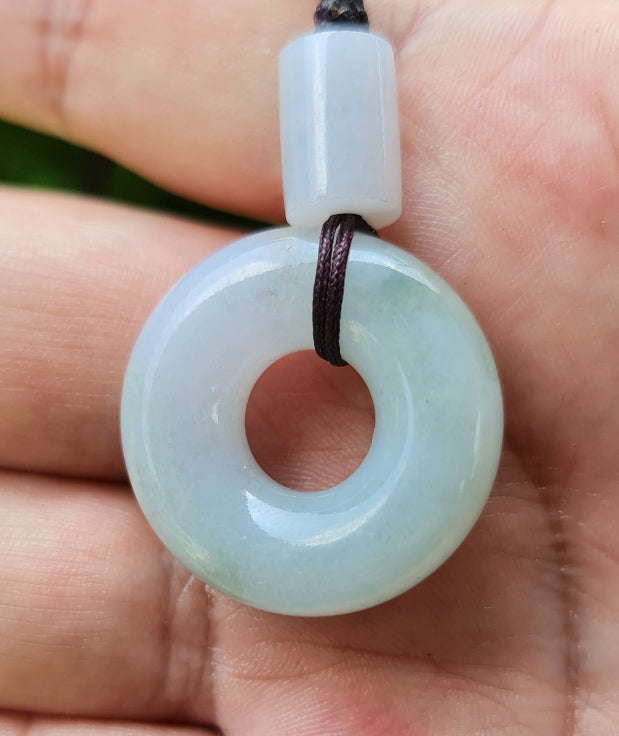 Untreated Type A Burmese jade pendant showing translucent luster with beautiful icy violet and soft green colors on a handwoven cord