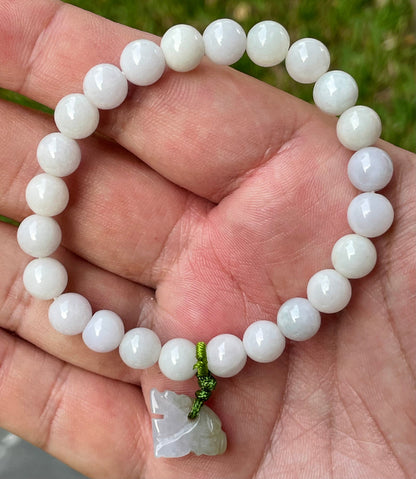 7.8mm natural Type A Burmese jade beads showing gentle translucency, white and lavender hues, and a hand-carved tiger pendant on the wrist