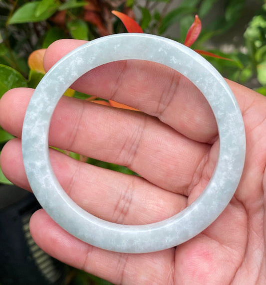 Close-up of a 58.2mm natural Grade A Burmese jadeite bangle featuring grey and milky white hues, item JB939