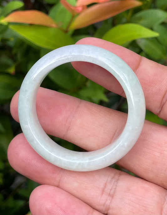 Close-up of a 36.4mm infant natural Grade A Burmese jadeite bangle featuring an icy light apple green hue, item JB883
