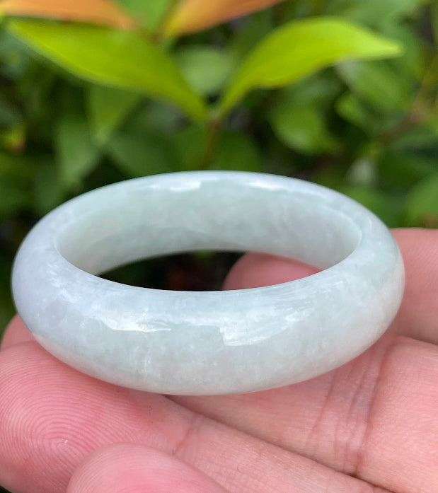 Handcrafted genuine Grade A Burmese jadeite infant bangle showcasing a translucent bright green appearance