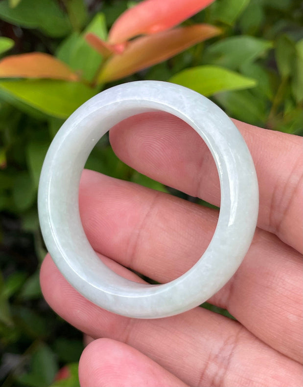 Handcrafted genuine Grade A Burmese jadeite infant bangle showcasing a translucent bright green appearance