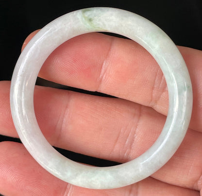Close-up of a 41mm princess cut natural Grade A Burmese jadeite bangle featuring icy light apple green and milky white hues, item JB251