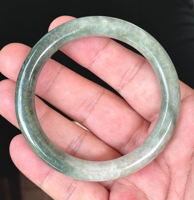 Close-up of a 56.8mm natural Grade A Burmese jadeite bangle featuring icy apple green and milky white hues, item JB403