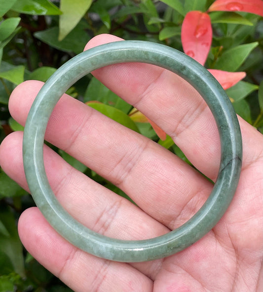 Close-up of a 60.8mm natural Grade A Burmese jadeite bangle featuring icy apple and moss green hues, item JB944