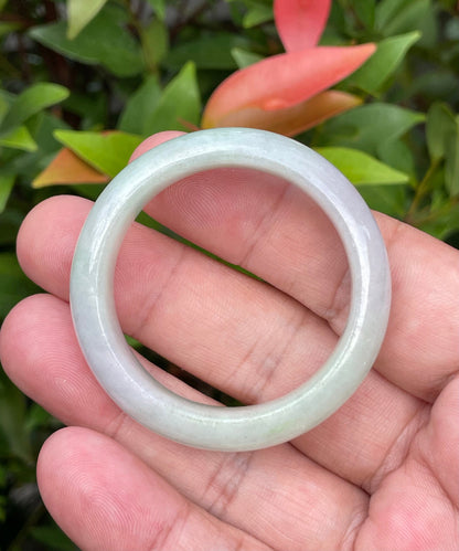 Close-up of a 39.2mm infant natural Grade A Burmese jadeite bangle featuring icy imperial green, lavender, and milky white hues, item JB885
