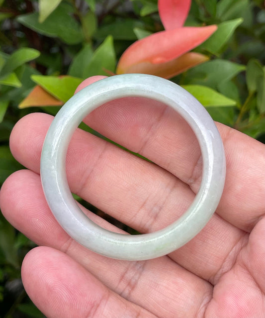 Close-up of a 39.2mm infant natural Grade A Burmese jadeite bangle featuring icy imperial green, lavender, and milky white hues, item JB885