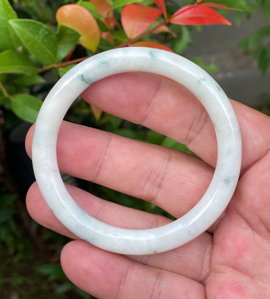 Close-up of a 55.4mm natural Grade A Burmese jadeite bangle featuring icy imperial green and milky white hues, item JB954