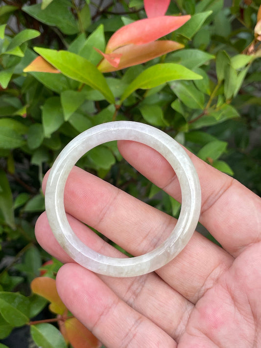 Close-up of a 44.5mm infant natural Grade A Burmese jadeite bangle featuring icy light yellow, white, and lavender hues, item JB890