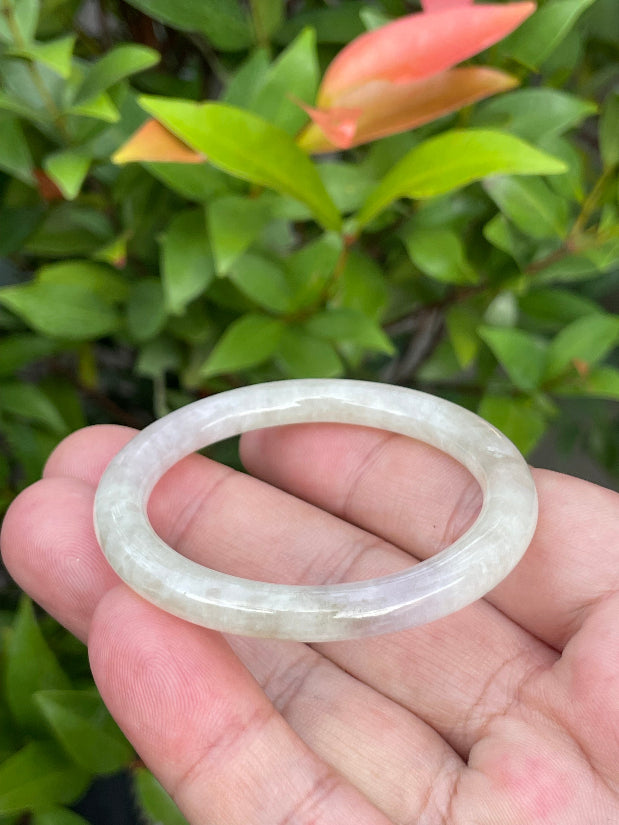 Handcrafted genuine Grade A Burmese jadeite infant bangle showcasing a translucent multi-colored appearance