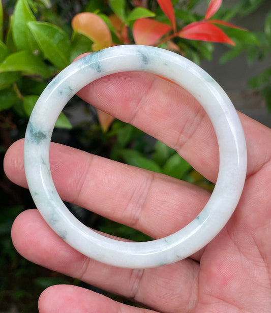 Close-up of a 55.3mm natural Grade A Burmese jadeite bangle featuring icy milky white and apple green hues, item JB950