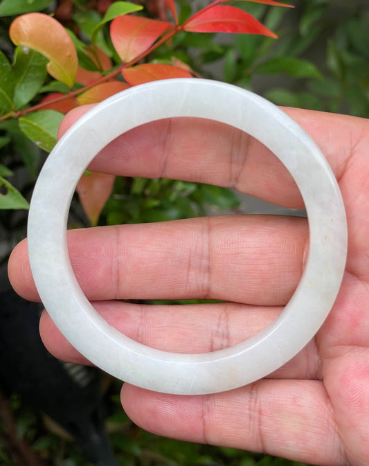 Close-up of a 58.2mm natural Grade A Burmese jadeite bangle featuring an icy milky white hue, item JB940