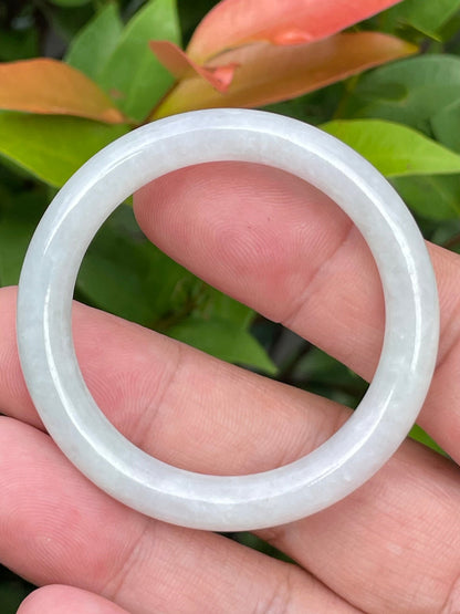 Close-up of a 40mm infant natural Grade A Burmese jadeite bangle featuring icy milky white and apple green hues, item JB882